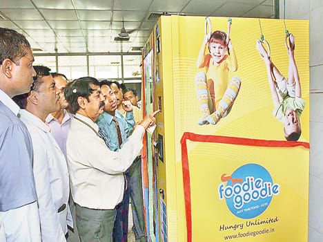 By inserting coins into the machine to get snacks, biscuits
