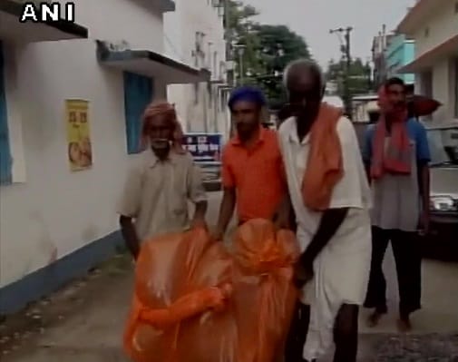 Three people carry dead body of relative in plastic bag