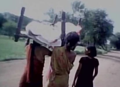 Three people carry dead body of relative in plastic bag