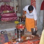 नगर क्षेत्र के शीतला मंदिर पर शारदीय नवरात्र की पूर्व संध्या पर मंदिर परिसर की सफाई करते पुजारी।
