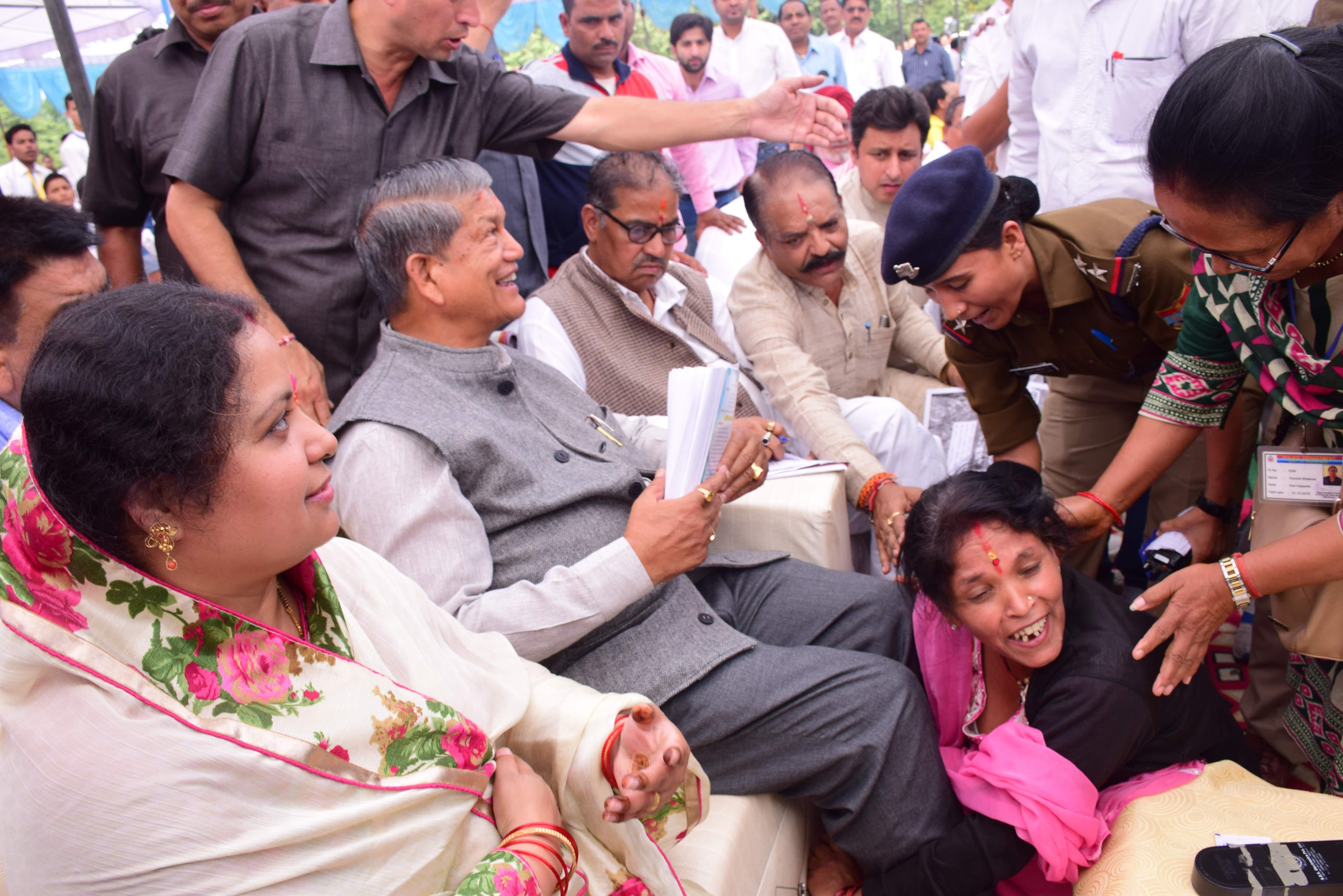 women fell down in CM haridh rawat feet.