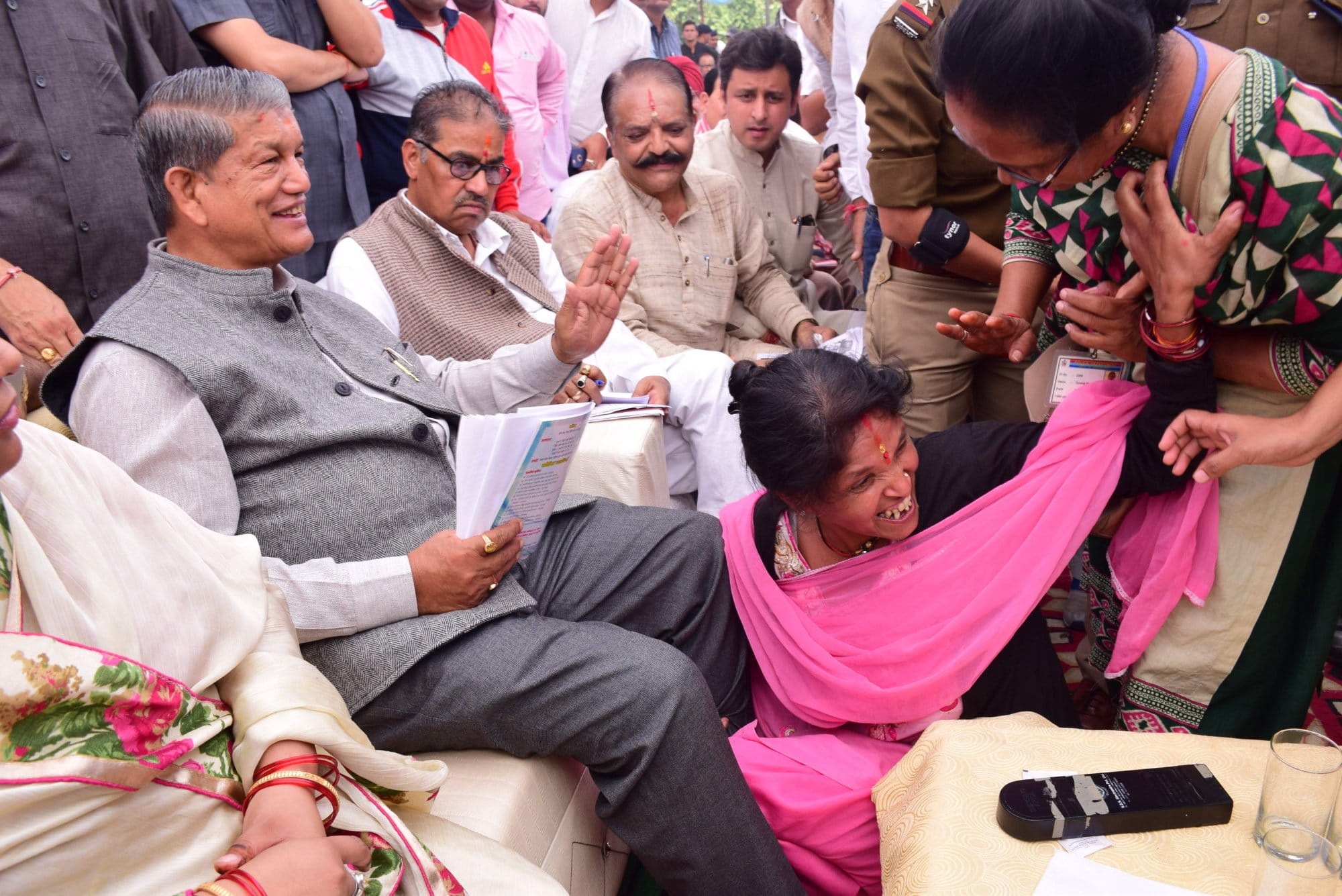 women fell down in CM haridh rawat feet.