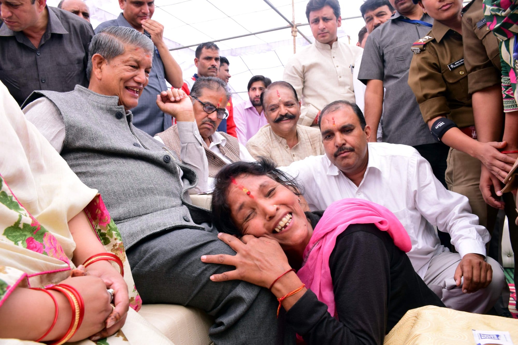 women fell down in CM haridh rawat feet.