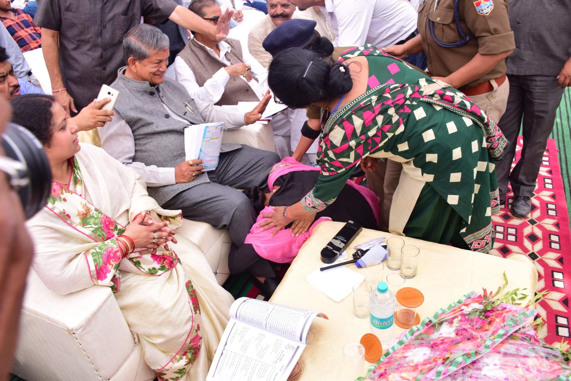 women fell down in CM haridh rawat feet.