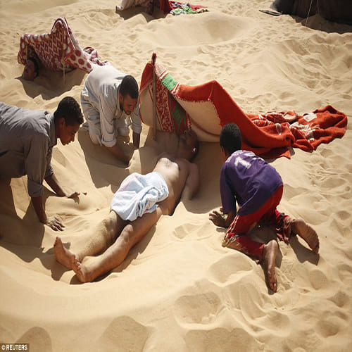 Egyptians bury themselves up to their necks for desert sand baths