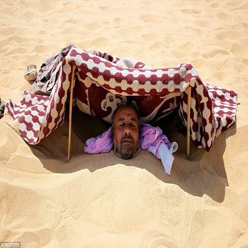 Egyptians bury themselves up to their necks for desert sand baths