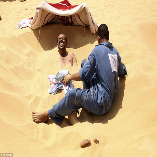 Egyptians bury themselves up to their necks for desert sand baths