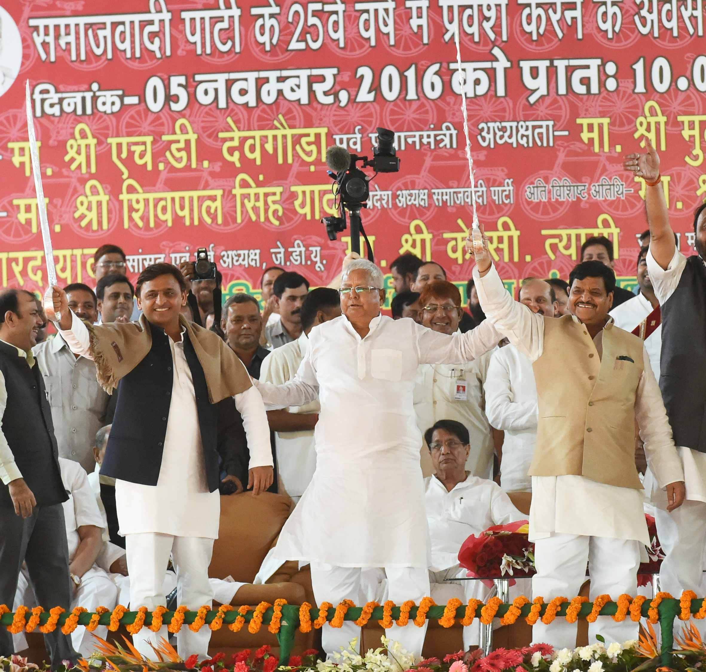akhilesh touches feet of shivpal on stage