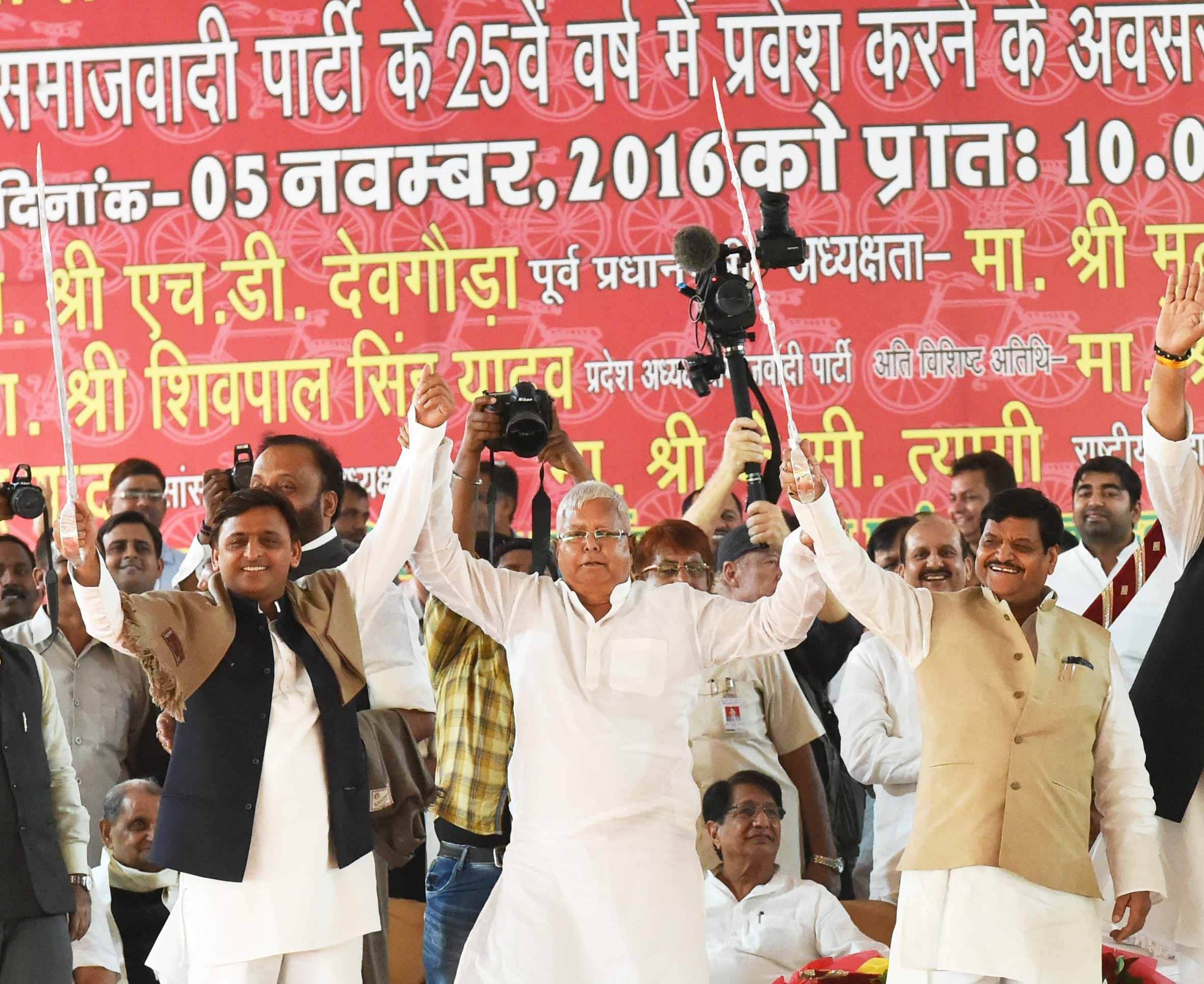 akhilesh touches feet of shivpal on stage