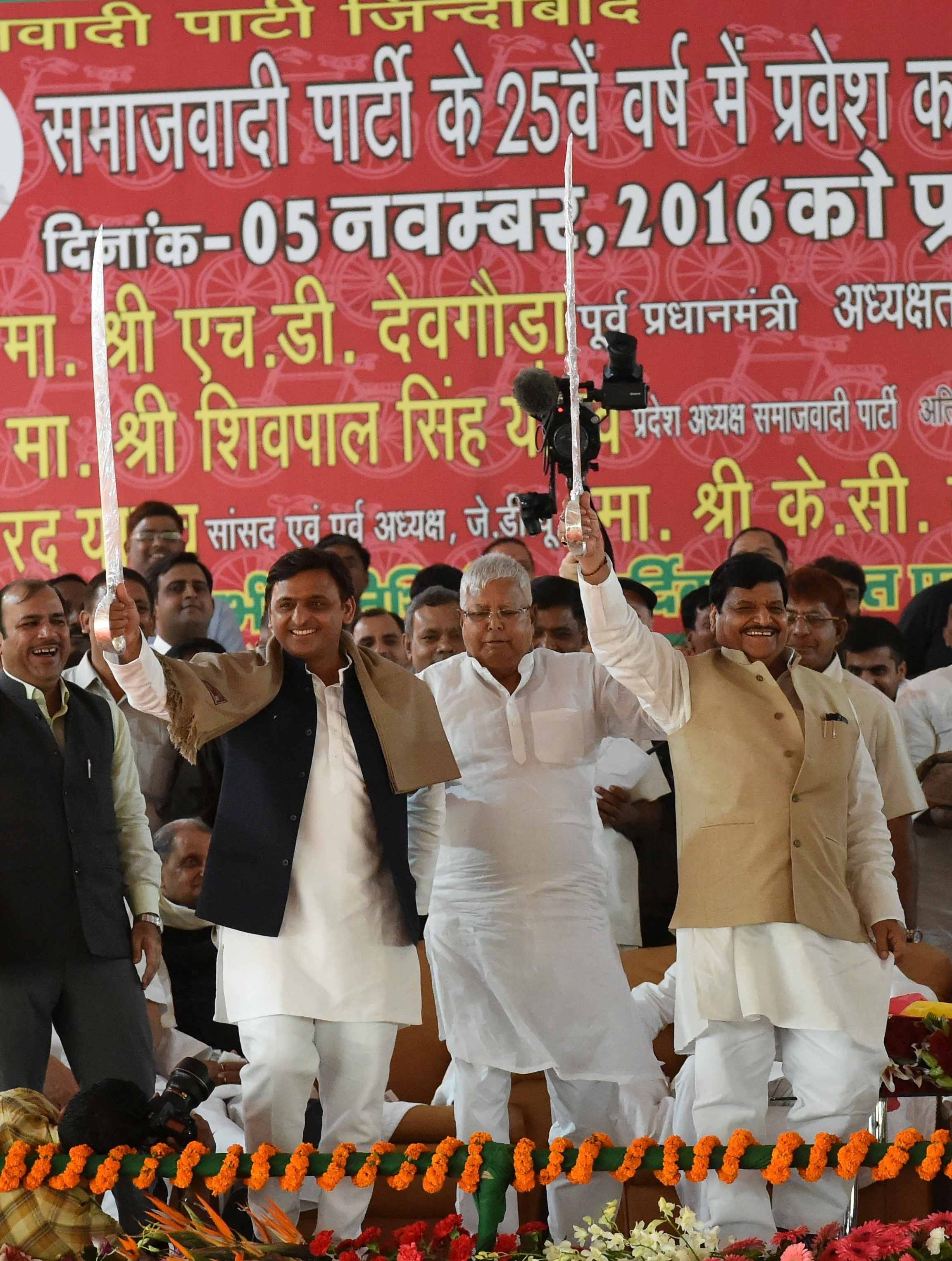 akhilesh touches feet of shivpal on stage
