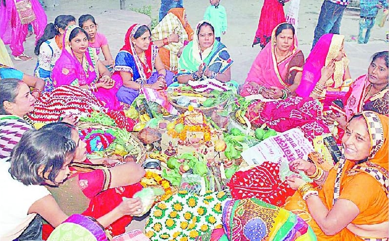 Women offer water to the declining sun
