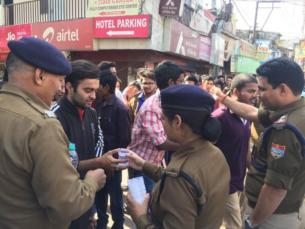 police bring water to people standing outside atm