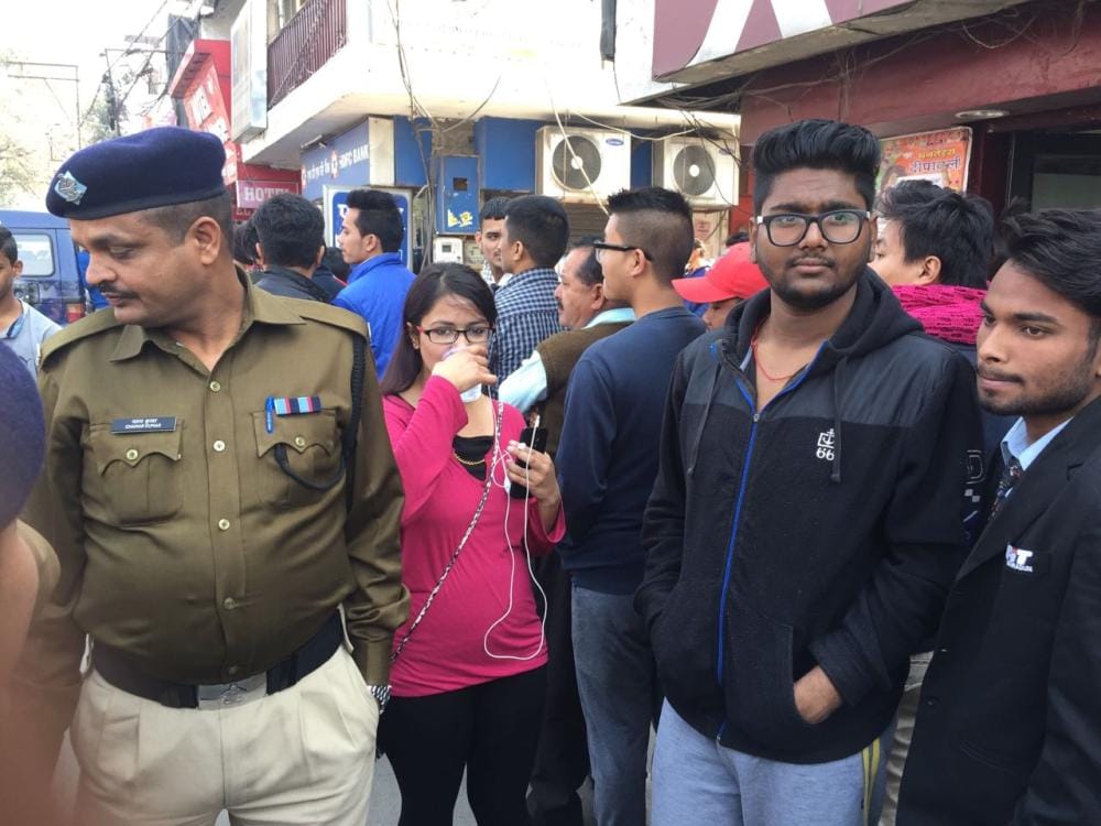 police bring water to people standing outside atm