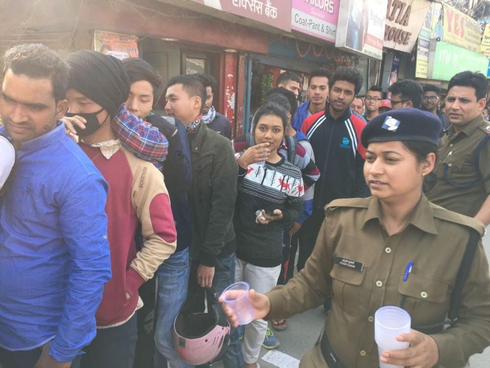 police bring water to people standing outside atm