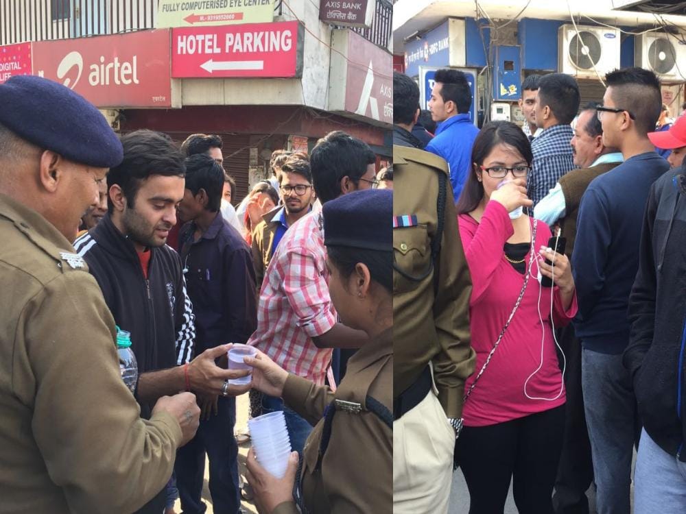 police bring water to people standing outside atm