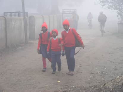 ठंड में स्कूल जाते बच्चे।