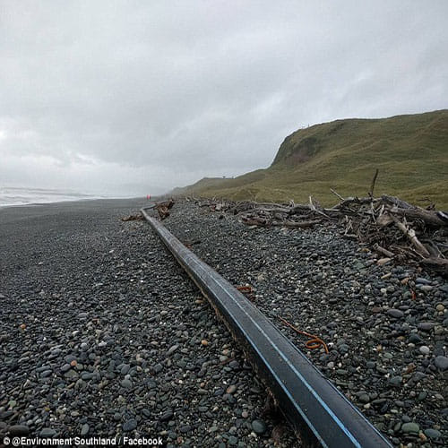 100 metre long pipe has washed up on a beach  