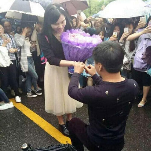 man proposes girlfriend with a bouquet made of currency