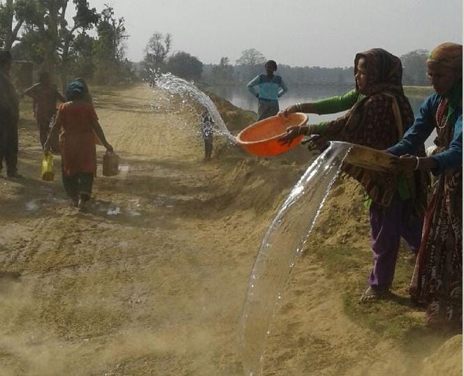 Disturbed by dust, women sprinkled water