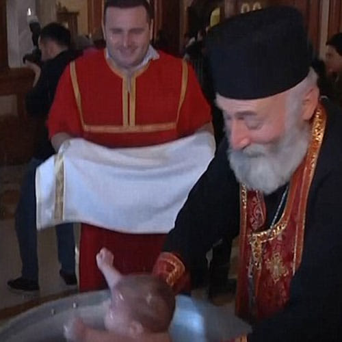 Patriarch of Church dunks babies roughly underwater