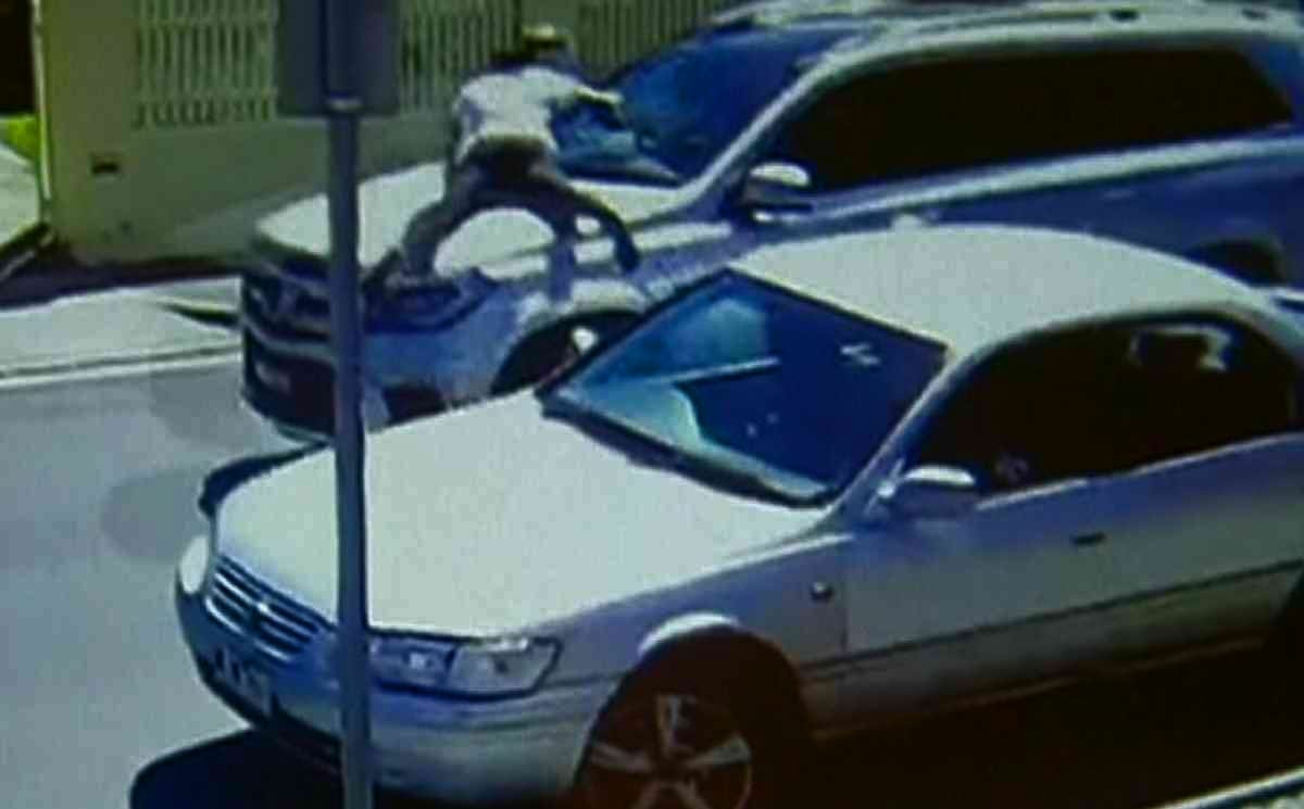 Young man hanging on the bonnet shouting 