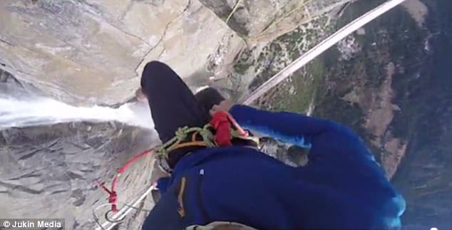 a man walks across 2500ft slackline above Yosemite Park's Upper Falls