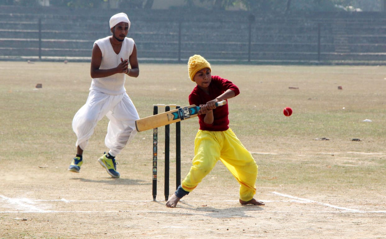 student playing cricket with dhoti and kurta in varanasi