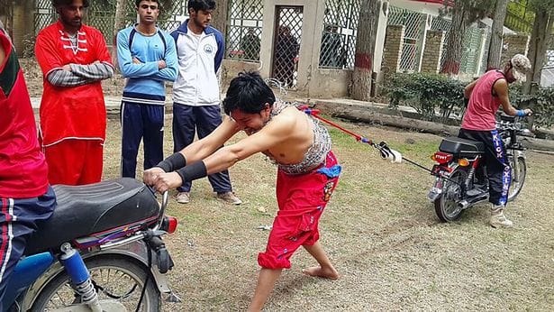 Fearless strongman lifts bricks with his EYELIDS while standing on nails.