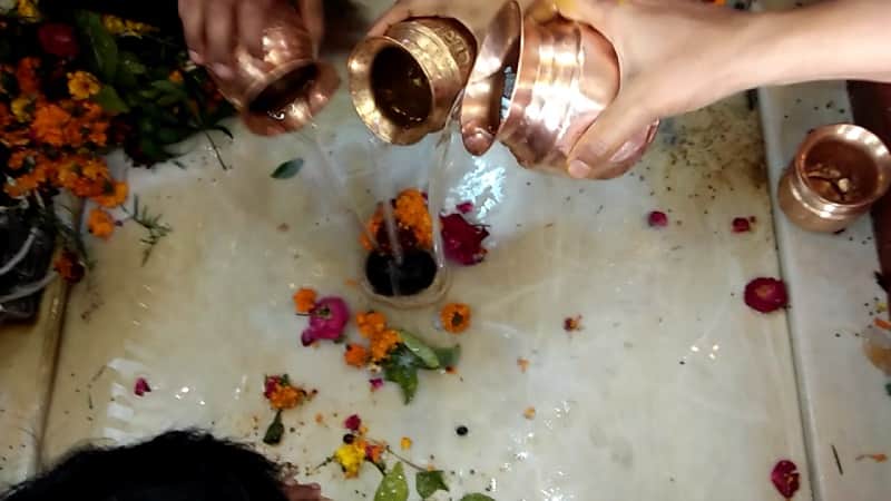 शिवलिंग पर जल चढ़ाते भक्त