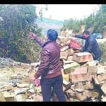 चंपावत में एक्सपायरी शराब नष्ट करते कर्मचारी।
