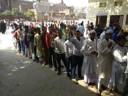 मतदान के लिए कतार में अपनी बारी का इंतजार करते लोग