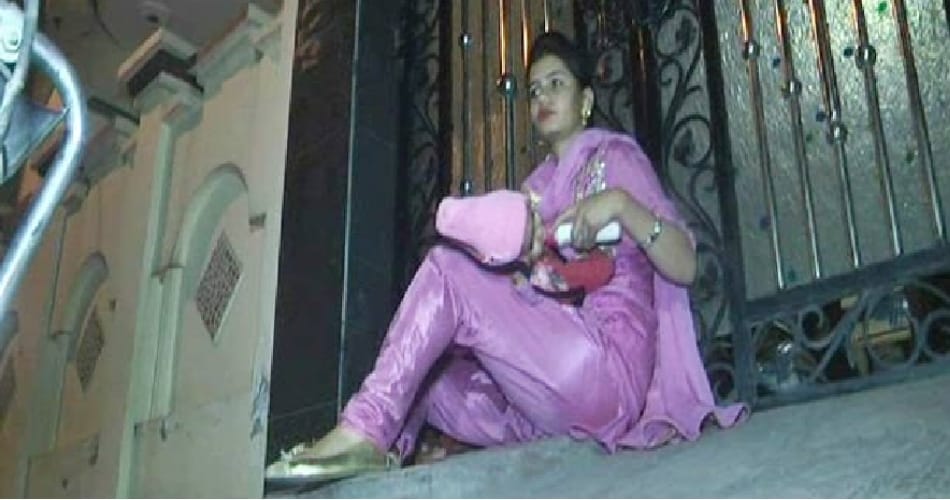 lady sit on protest with 5 month old child outside house against husband and in-laws