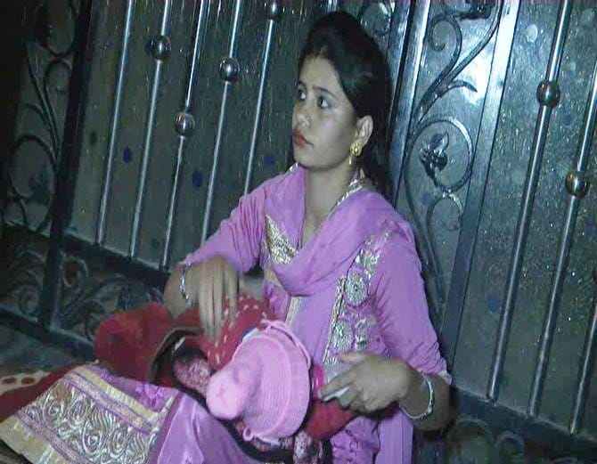 lady sit on protest with 5 month old child outside house against husband and in-laws