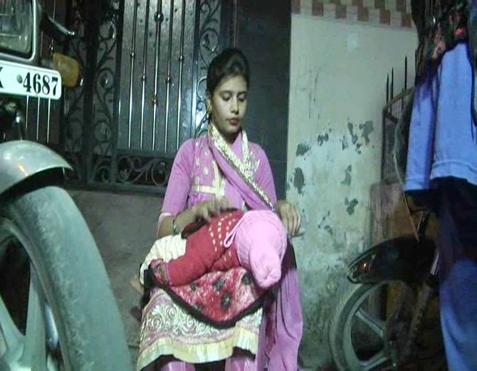 lady sit on protest with 5 month old child outside house against husband and in-laws