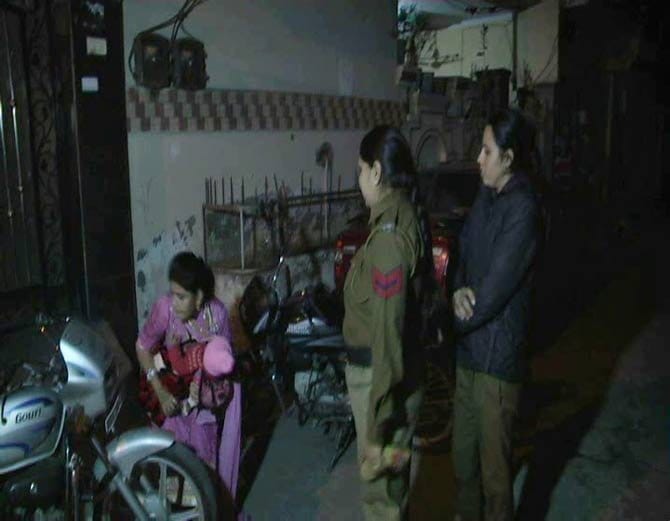 lady sit on protest with 5 month old child outside house against husband and in-laws