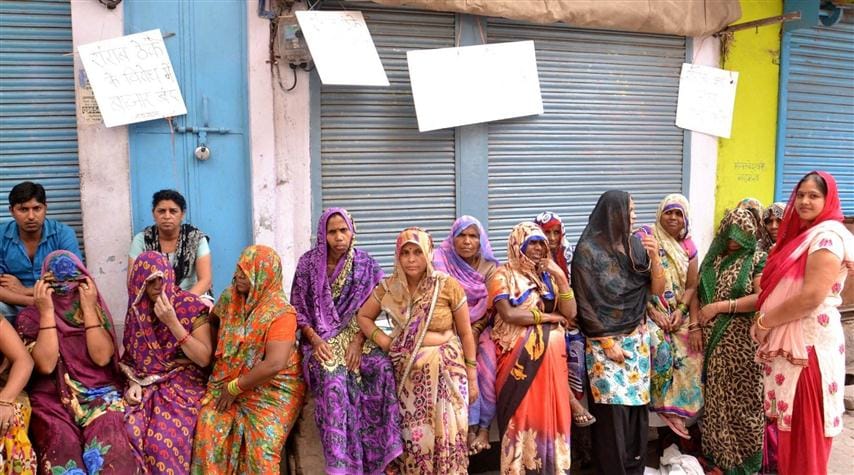 The market closed when the liquor shop opened, women sitting on the dock