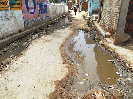 The dirt of the village, the bungalows shining the officials