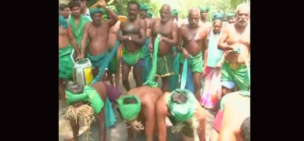Tamil Nadu farmers eat grass protesting for drought relief funds in Delhi.