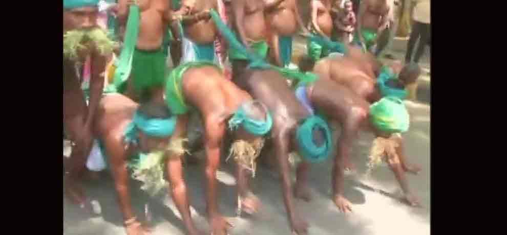 Tamil Nadu farmers eat grass protesting for drought relief funds in Delhi.
