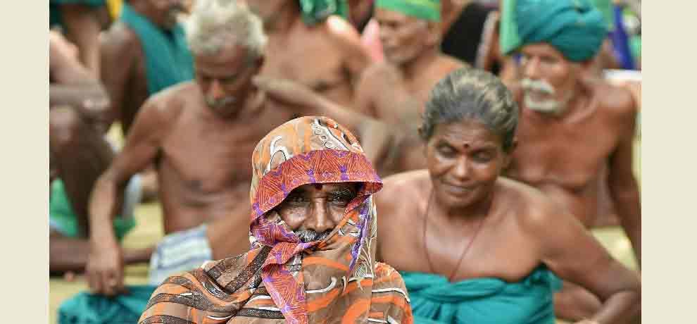 Tamil Nadu farmers eat grass protesting for drought relief funds in Delhi.