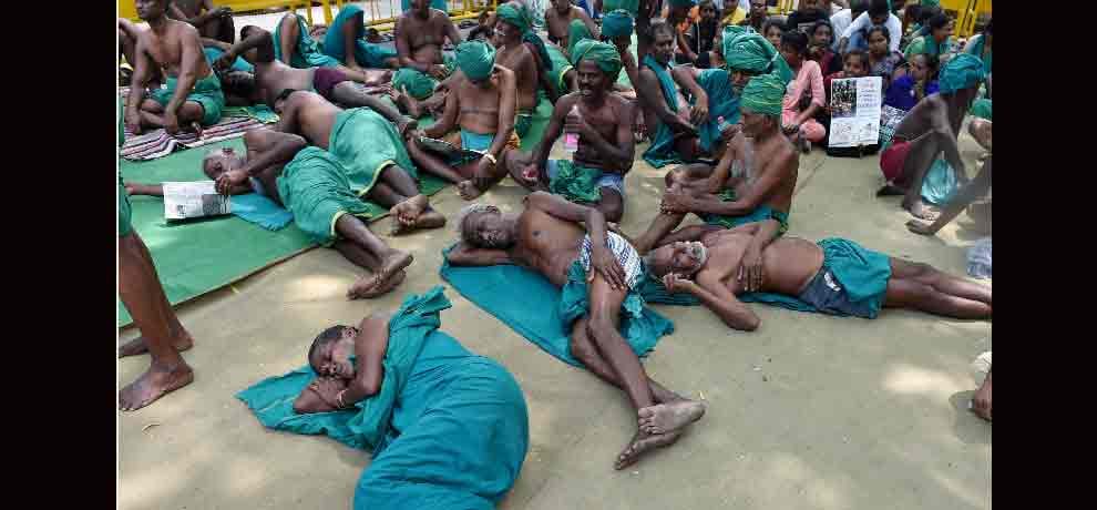 Tamil Nadu farmers eat grass protesting for drought relief funds in Delhi.