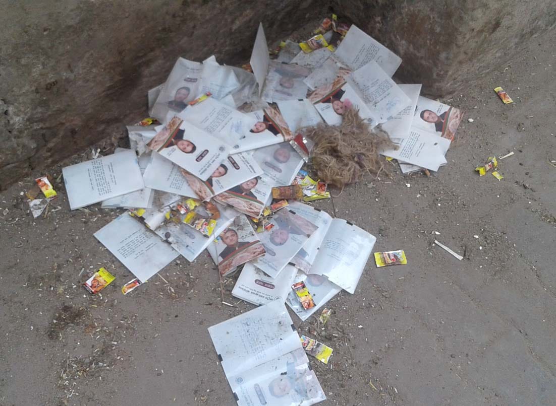 Ration card cover with photograph of Akhilesh thrown in a garbage pile