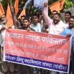 विवादित बैनर के साथ प्रदर्शन करते लोग
