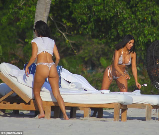 Kim and Kourtney Kardashian parade their beach bods in matching silver bikinis 