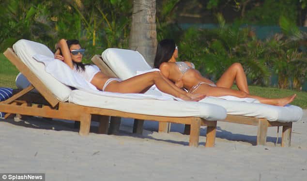 Kim and Kourtney Kardashian parade their beach bods in matching silver bikinis 