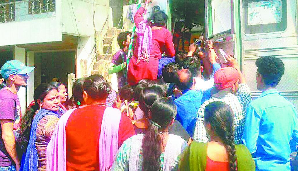 Women climb on trucks to get cylinders