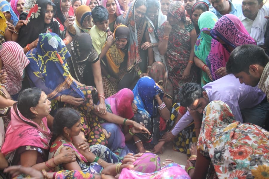 people mourning in the village of agra after death of 14 men