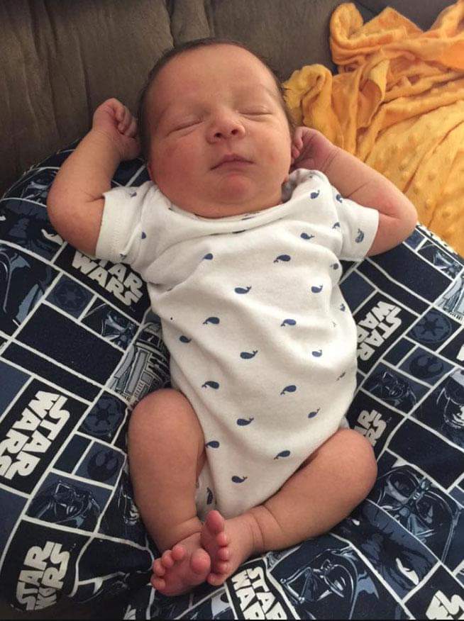 new born baby holding contraceptive in his hand during parturition