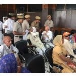 लघु सचिवालय में परिवाद एवं कष्ट निवारण समिति की मीटिंग के दौरान लोगों को उठाती पुलिस