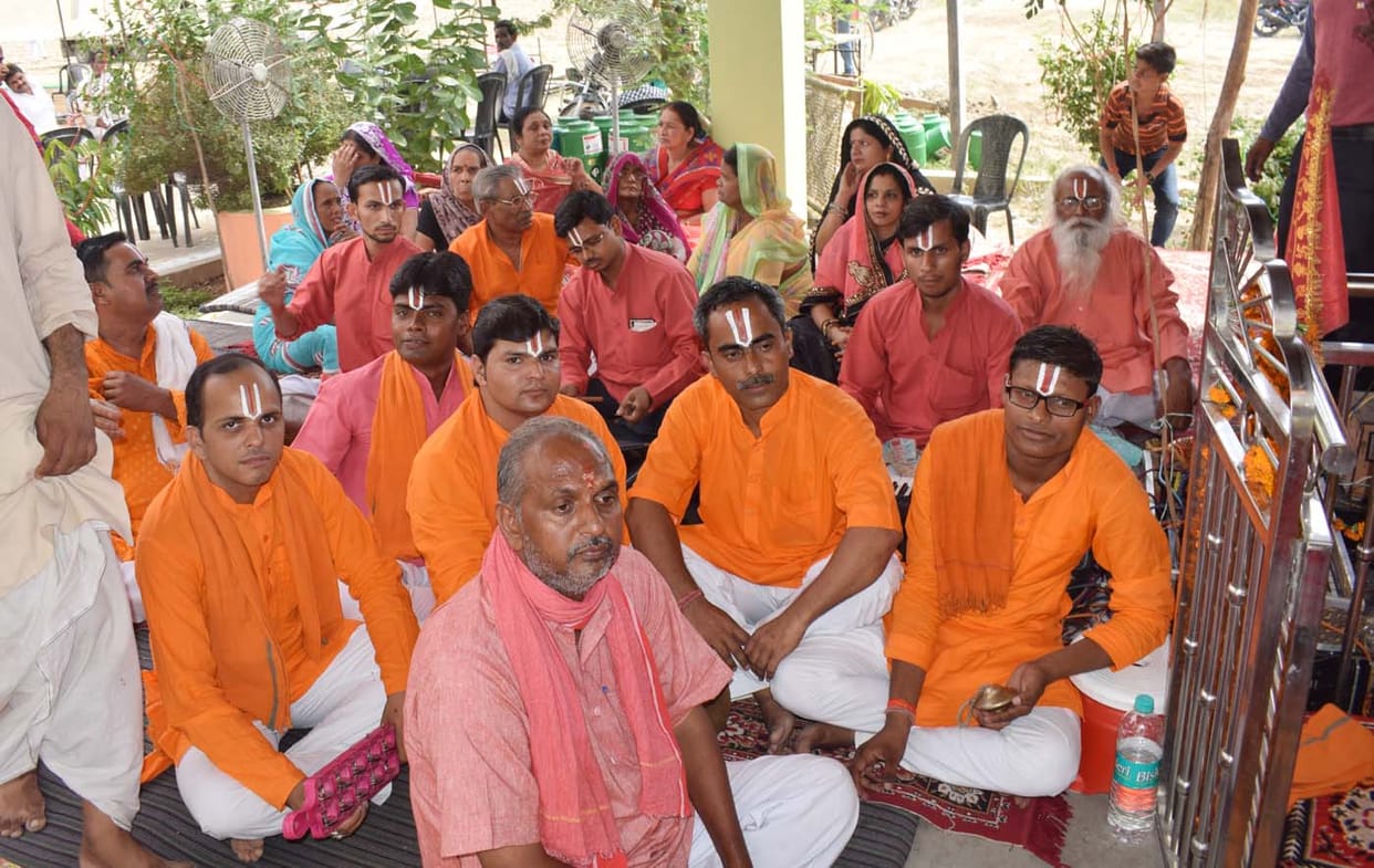 Devotees engaged in mantra mantrascharna bhandare in havan